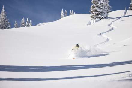A skier navigates deep powder snow on the Ski Utah Interconnect Tour