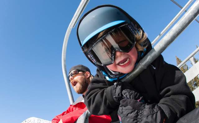 Dad and son on ski chairlift at Brighton