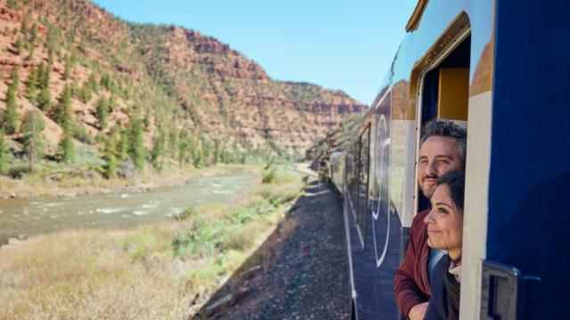 Two guests on the Canyon Spirit railway line looking out of the train in Utah.