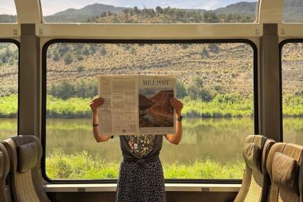 Woman reading a newspaper on the Canyon Spirit railway.