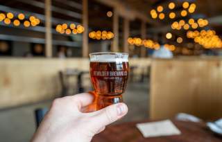 Hand holding a Bewilder beer