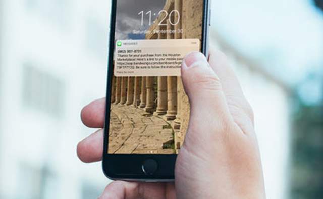 Hand holding phone with a text notification on the screen