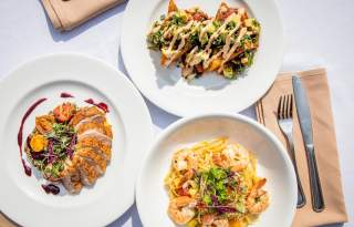 3 course meal on 3 plates with fork and knife on a cloth napkin
