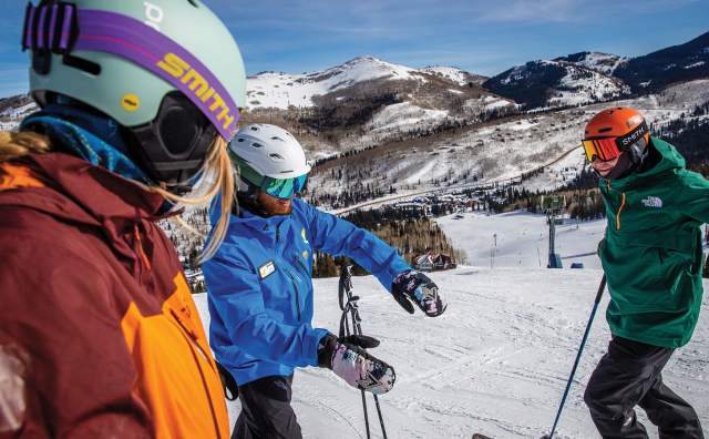2 skiers and 1 instructor on skis on the mountain at Solitude