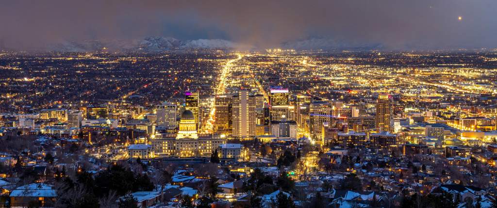 Aerial view of Salt Lake at night looking south down main street from above the capitol building. The city is lit up with yellow lights.