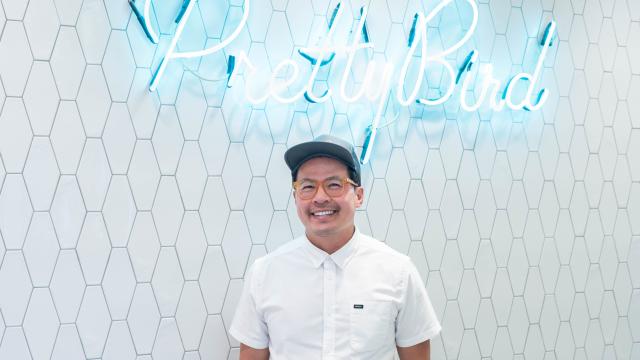 Viet Pham in front of the Pretty Bird sign